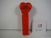 Front of the Pez dispenser showing the heart-shaped top with 'Happy Valentine's Day' inscription and red stem.