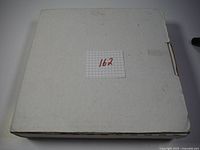 Closed white cardboard original box with label number 162.