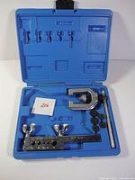 Blue plastic case with tube flaring bar, flaring tool, and six dies arranged inside.