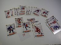 Overview photo showing 41 hockey cards laid out in rows on a white background with a small grid paper labeled '73' nearby.