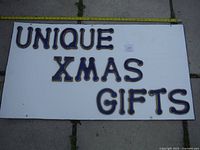 Photo of the full handmade sign with letters arranged on a white board spelling 'UNIQUE XMAS GIFTS'