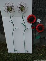 Two tall metal wire flower garden stakes with glow-in-the-dark ceramic balls at center plus two shorter red flower stakes with leaves.
