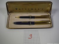 Photo of the Waterman's pen and pencil set in the original satin-lined case showing both items secured with elastic bands.