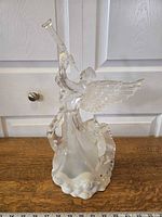 Full front view of transparent acrylic angel figurine holding a trumpet, measuring around 10.5 x 15.5 inches.