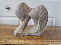 Side angle showing the intertwined faces in a kiss with detailed hair and facial features.