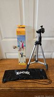 Full setup of Kodak TR501 tripod standing with black adjustable head, alongside black Kodak carrying case and original yellow Kodak box.