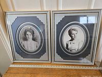 Pair of antique portraits of women, framed with oval mats and gold frames