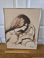 Frontal image of the signed 1950s pastel portrait of a girl holding a string of beads, showing full artwork in frame with ruler for size reference.