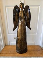 Front view of the tall handcrafted primitive coppertone patchwork metal angel sculpture.