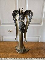 Front view of one vintage Pier 1 metal and glass angel candle holder showing gold tone and textured glass wing details.