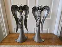 Pair of vintage silver-tone metal and glass angel candle holders on wooden table, with ruler showing 12-inch scale for size reference.