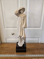 Front view of the Windblown sculpture showing the woman in a flowing dress holding her hat.