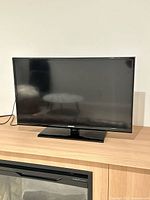 Front view of 32-inch Samsung LED TV on stand showing screen and bezel.