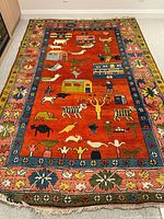 Full view of rug laid flat showing central figural field and border