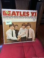 Front cover of the Beatles VI album showing the Beatles members standing together, wearing ties and smiling. The front cover is colored with bold red lettering spelling 'BEATLES'.