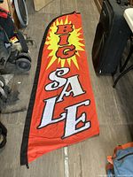Full length of the red and yellow promotional flag showing the text 'BIG SALE' in large letters with a black border on one edge.