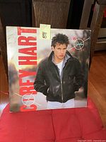 Front cover of the album featuring Corey Hart with jacket, red vertical text, and target graphic.