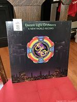Front cover of the ELO 'A New World Record' album showing the colorful logo and dark cityscape