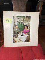 Front cover of the Led Zeppelin Presence album showing embossed text and photo of people at a table.