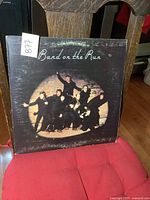 Front cover of the Band on the Run album showing the band members in black under a spotlight with pebbly textured cover.