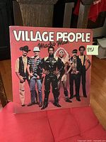 Front cover of Village People Macho Man vinyl record album showing band members in costumes against pink background.