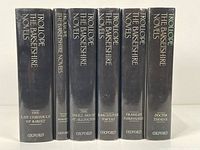 Six volumes of Anthony Trollope's "The Barsetshire Novels" standing upright, showing spine titles clearly, all in black dust jackets with gold and cream lettering. Oxford Press editions.