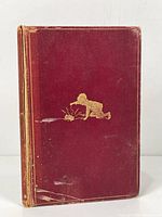 Front cover with gold embossed illustration of a boy playing with a toy on red cloth cover, showing discoloration and wear.