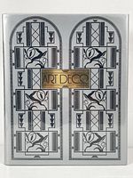 Front cover of the book showing silver dust jacket with black and gold Art Deco geometric artwork and title