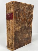Front cover of the book, showing worn leather binding with red spine label