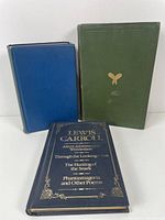Three hardcover vintage books standing upright showing front covers and spines. Lewis Carroll book in blue with gold embossing, Jaunts and Jollities in green, The Plays in blue-green.
