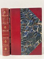 Front cover and spine of red leather-bound book with marbled paper cover titled 'Beaux and Belles of England'. Gold embossed floral pattern and title on spine.