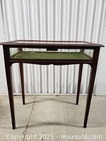 Full view of antique wooden display table showing slim tapered legs, rectangular top glass display area, and overall shape.