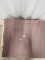 Top view of a brown textured album cover with embossed His Master's Voice logo of dog and gramophone