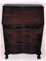 Front view of mahogany Chippendale slant-top bureau showing serpentine front and brass handles