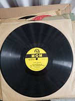 Record showing label for Hank Williams 'On the Banks of the Old Ponchartrain'. Yellow MGM label, visible surface wear.