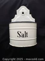 White enameled metal salt container with 'Salt' wording and rust shown.