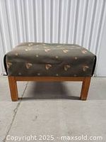 Photo of a rectangular ottoman with wooden legs and patterned upholstery that is not original forest green, showing minor leg abrasions.