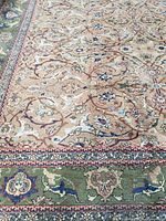 Overall view of the carpet showing detailed floral and traditional designs with clear view of border colors and pattern.