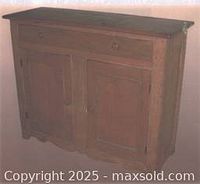 Front view of antique blondewood sideboard showing two drawers above two cabinet doors with wood grain visible and some wear.
