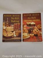 Two vintage Robin Hood No-Sift Flour baking cookbooks showing front covers side by side on a beige surface.