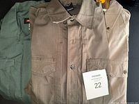 Three shirts stacked showing fronts and Carhartt, Tru-Spec, 5.11 labels