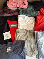 Group of shirts, tees, tank and tie laid out