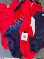 Front view of four TYR swimsuits showing colors and tags