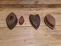 Four cast iron sad irons lined up on wooden surface
