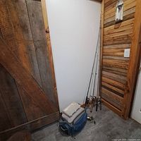 Three spinning rods with reels, tackle boxes and bag on floor