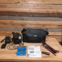 Full lot view showing camcorder, bag, charger, tapes, manual, remote, strap