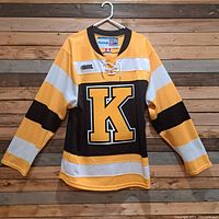 Full front view of Kingston Frontenacs hockey jersey on hanger