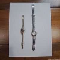 Both wristwatches displayed side by side on white background