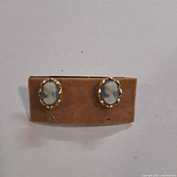 Front view of both cameo earrings showing blue and white profiles and gold-tone bezels