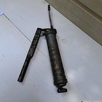 Full view of Plews G17 grease gun with handle and nozzle